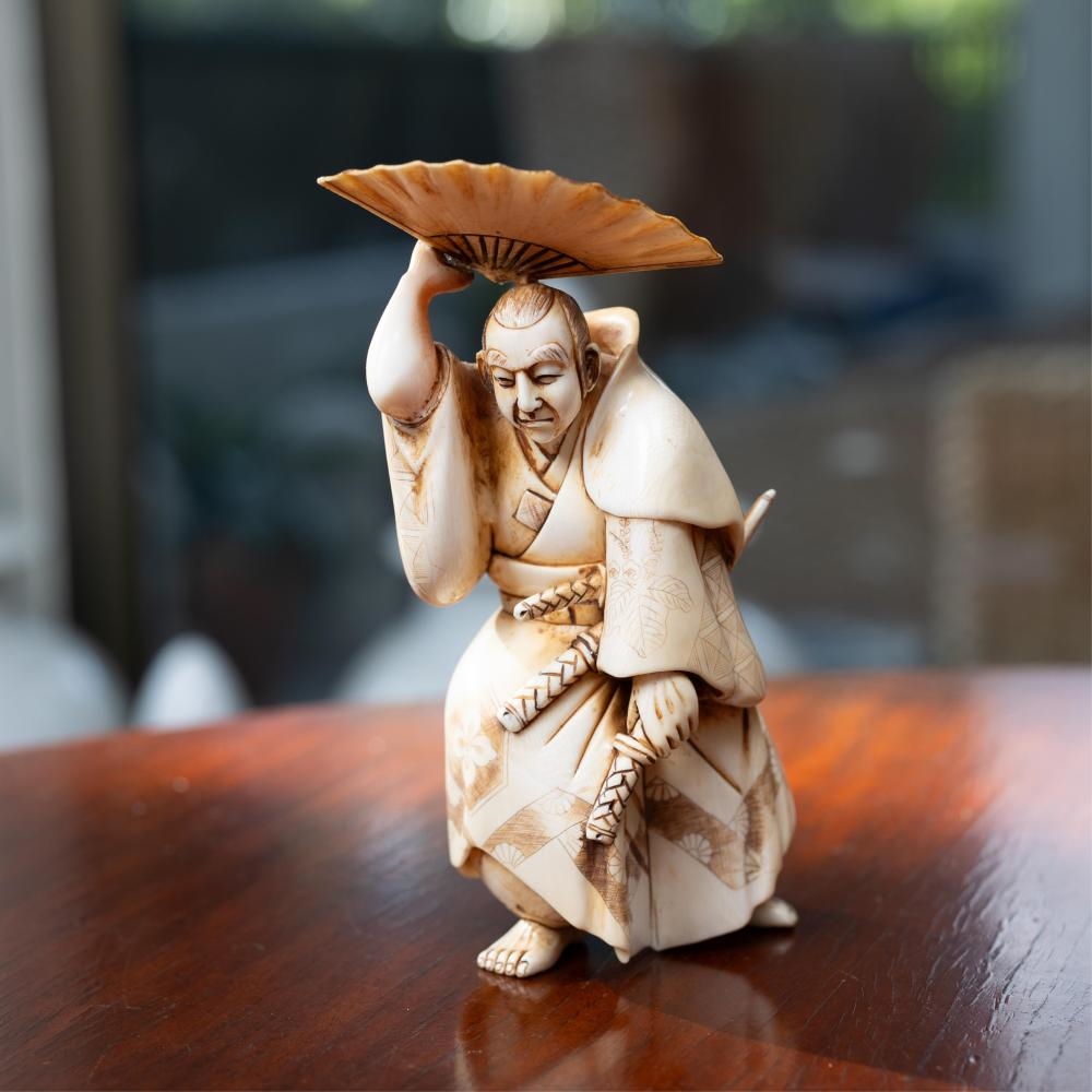 Japanese School | A Japanese carved ivory okimono of a samurai