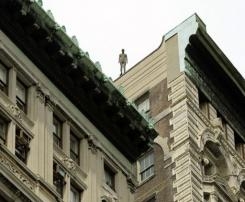 Lifelike statues teeter at edge of New York rooftops