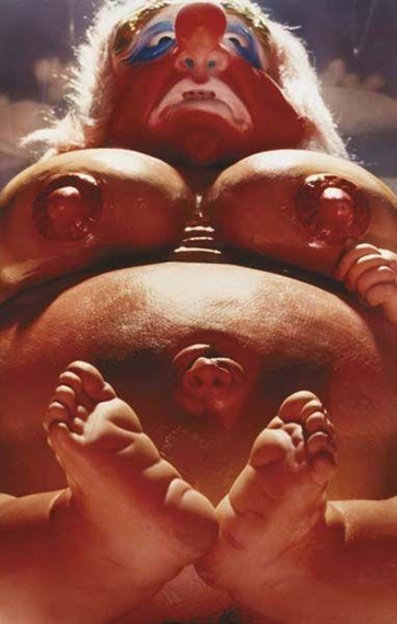 A surreal, close-up portrait of a figure with a monkey-like face and exposed body parts.