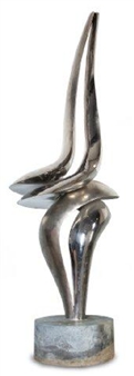 A sleek, abstract sculpture featuring a fluid, metallic figure standing on a rough base.
