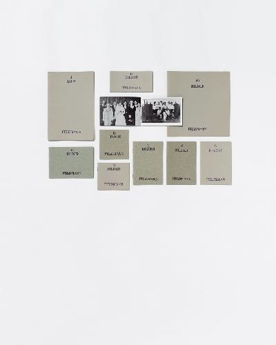 A minimalist arrangement of beige paper cards with black text and two small black-and-white photographs on a white background.