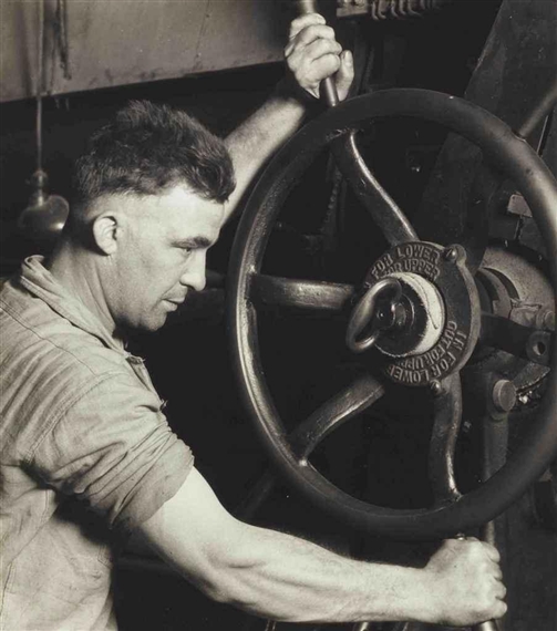 An Industrial Design: Pennsylvania Rubber Co. At the control wheel of a great 'calendar' - making auto tires, 1920s by Lewis Hine, printed 1930s