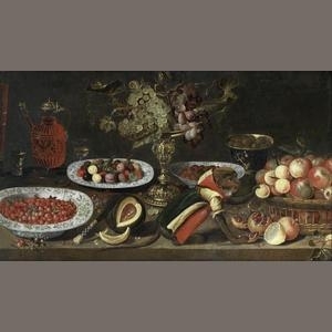 Grapes in a tazza, a glass and carafe of red wine, a bowl of strawberries, a split melon, a clothed monkey, a bowl of olives and a basket of apples on a wooden table - Artus Claessens