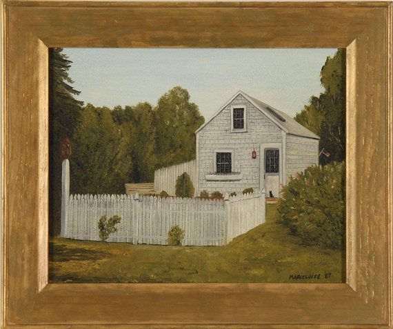 Black cat on the stoop of a white-shingled shed surrounded by a picket fence