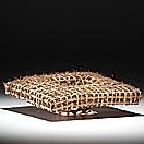 "A woven basket-like sculpture with a dark base."