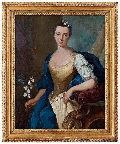 Portrait of a lady standing by a console table, holding white and blue flowers by Joachim Rupalley