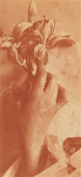 A sepia-toned close-up of a hand holding a wilting flower.