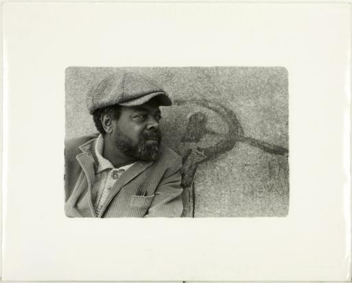 AMIRI BARAKA, AKA LEROI JONES IN THE SHADOW OF COMMUNIST GRAFFITI, NCY by Gerard Malanga, 1981