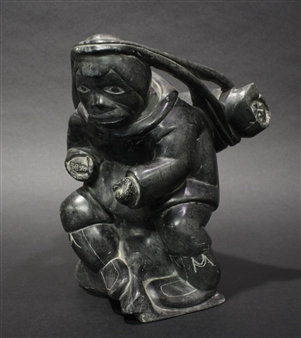 Carving of an Inuk carrying a package on his back - Levi Komak