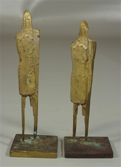 A pair of abstract bronze figures standing on rectangular bases.