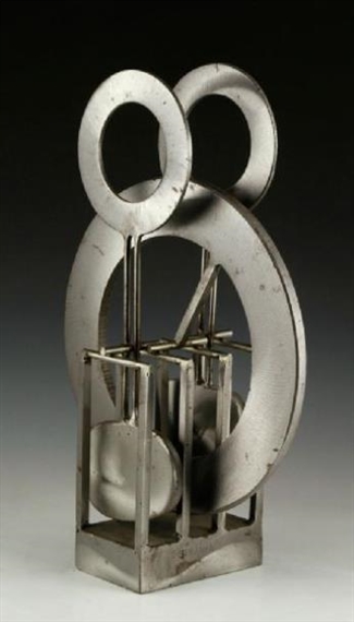 A metallic abstract sculpture featuring interlocking rings and a geometric base.