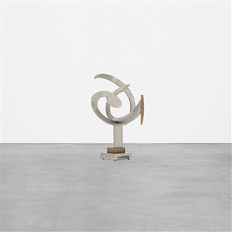 A minimalist sculpture featuring a twisted metal form mounted on a simple rectangular base.