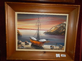 A framed painting of a small boat at sunset with rocky cliffs and a colorful sky.