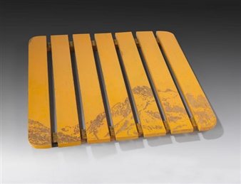 A slatted wooden chair with a yellow finish and mountain landscape design.