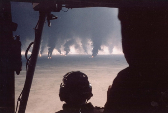 La fin de la guerre du Golfe. Les Irakiens mettent le feu aux puits de pétrole du Koweït bientôt libéré par les forces alliées. A bord d'un hélicoptère, des militaires observent la scène. by Benoit Gysembergh, 1991, printed later