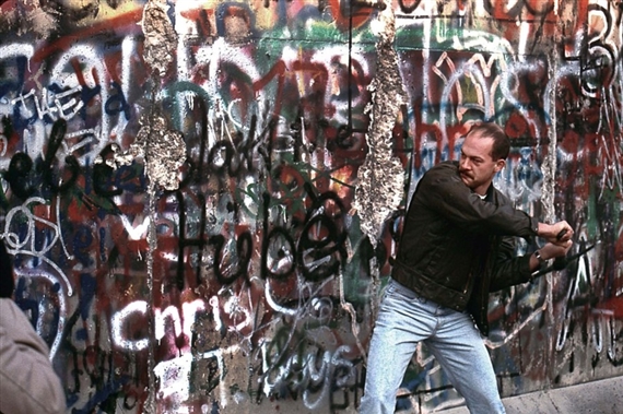La chute du mur de Berlin. Un homme casse le Mur à coups de pioche. by Benoit Gysembergh, 1989, printed later