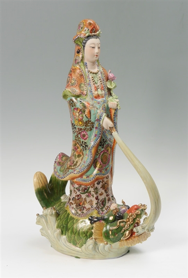 CHINESE POLYCHROME FIGURE OF QUAN YIN ON FISH:  Polychrome decorated ceramic figure of Quan Yin or Guanyin holding a lotus blossom, standing atop a fish by Yin Quan