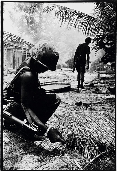Soldiers in ravaged village by Philip Jones Griffiths, 1967