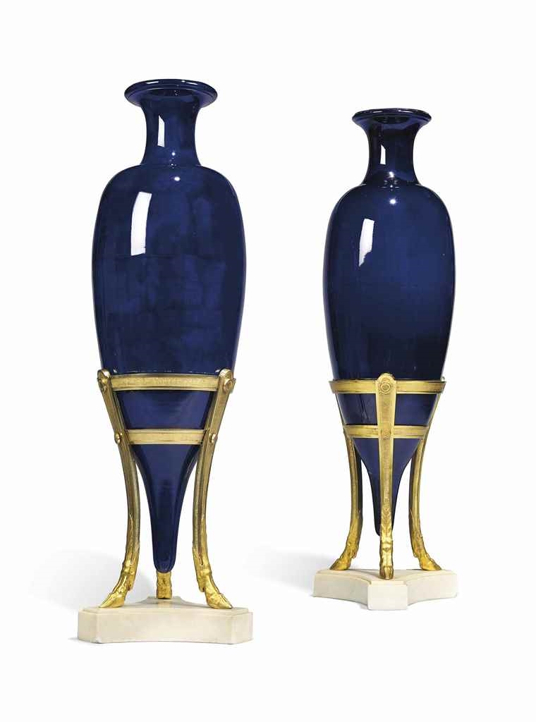 Artwork by Jean-Claude Chambellan Duplessis, A PAIR OF LOUIS XVI ORMOLU, WHITE MARBLE AND DARK BLUE-GROUND 'LACRIMAL' VASES ON STANDS, Made of Each vase with flared neck and tapering body, supported on a tripod with milled ring bands, squared milled legs and hoof feet, on a concave-sided base, possibly conceived with mounts to the rims