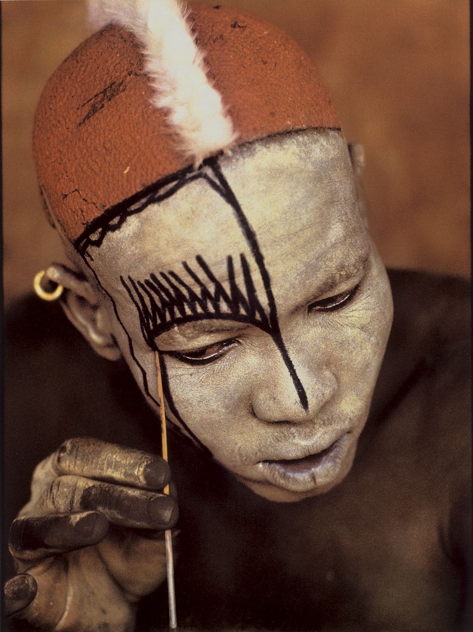 Nuba man applying mask by Leni Riefenstahl, 1975