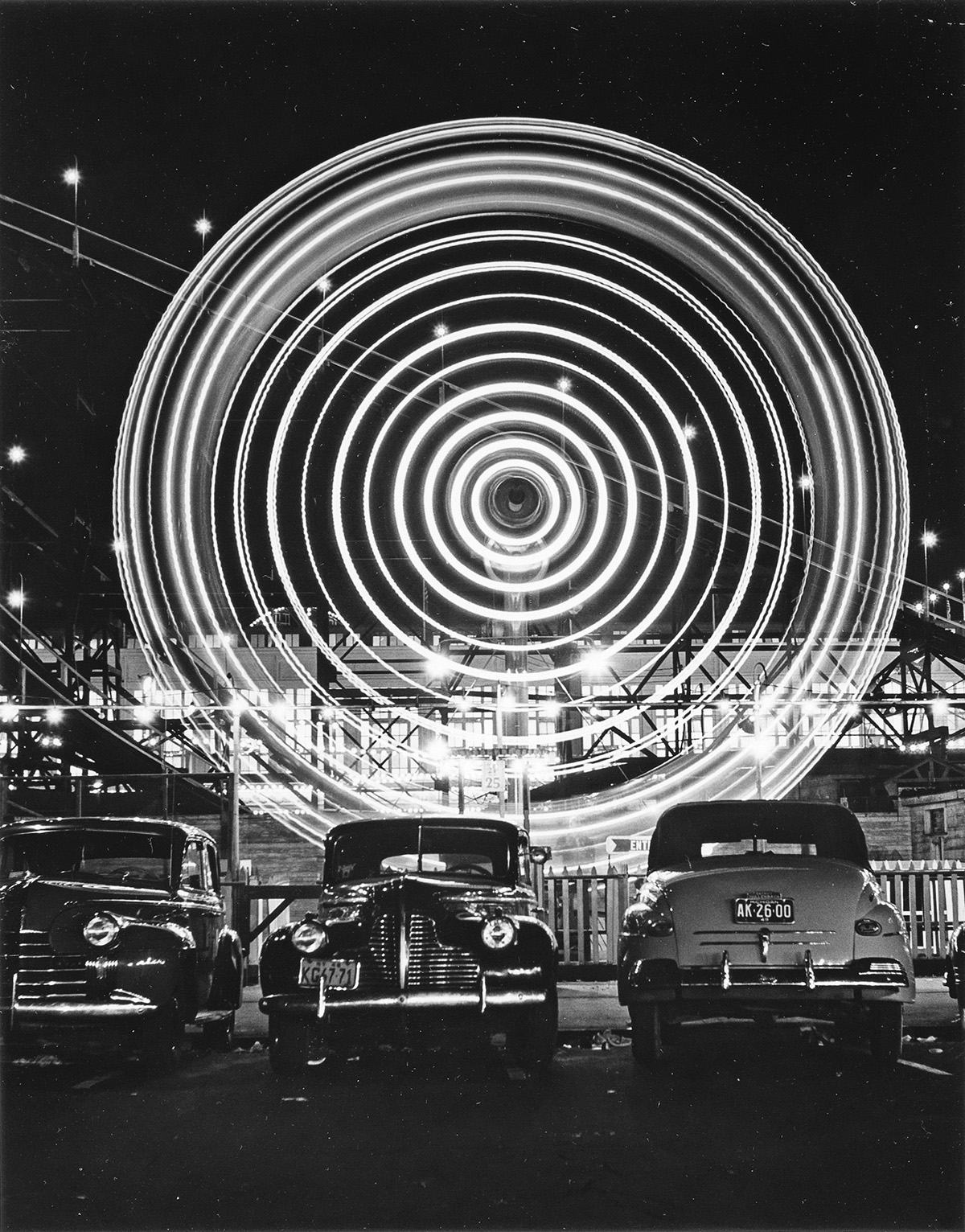 Night scene with cars and abstraction of ferris wheel