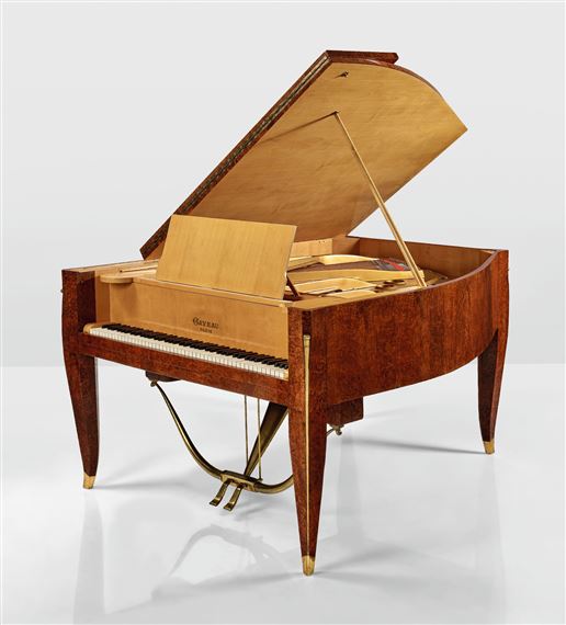 A wooden grand piano with its lid open, revealing the internal mechanism against a plain background.