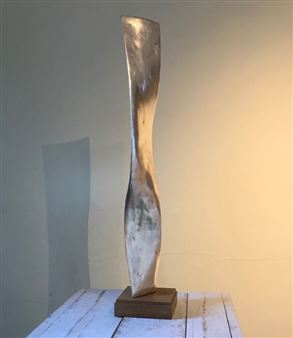 A tall, abstract sculpture with a twisted form and metallic finish stands on a wooden base.