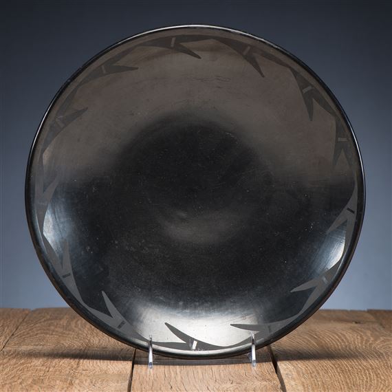 light gunmetal finish; repeating geometric motif, signed on base Maria and Santana,  height 2 in. x diameter 12 in. 
1943-1954 by Maria Montoya Martinez, Santana Roybal Martinez, 1943-1954