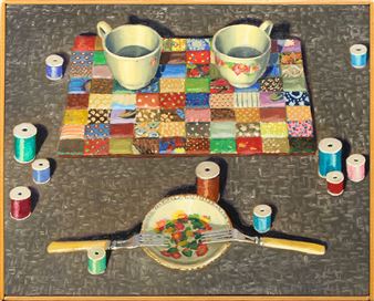 A still life composition featuring two cups on a colorful patchwork mat surrounded by spools of thread and a small plate with cutlery.