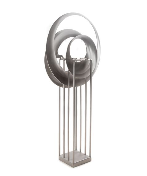 A minimalist sculpture featuring interlocking rings mounted on a vertical grid stand.