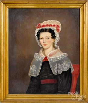 A formal portrait of a woman in Victorian-era attire, framed by a gilded border.