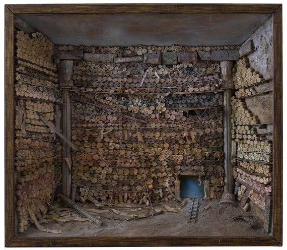 A diorama of a subterranean chamber filled with stacked cylindrical objects.
