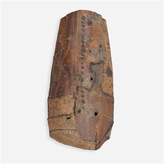 A weathered, stitched leather artifact with geometric markings and visible wear.