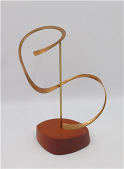 A minimalist metal sculpture featuring a stylized letter 'S' resting on a wooden base.