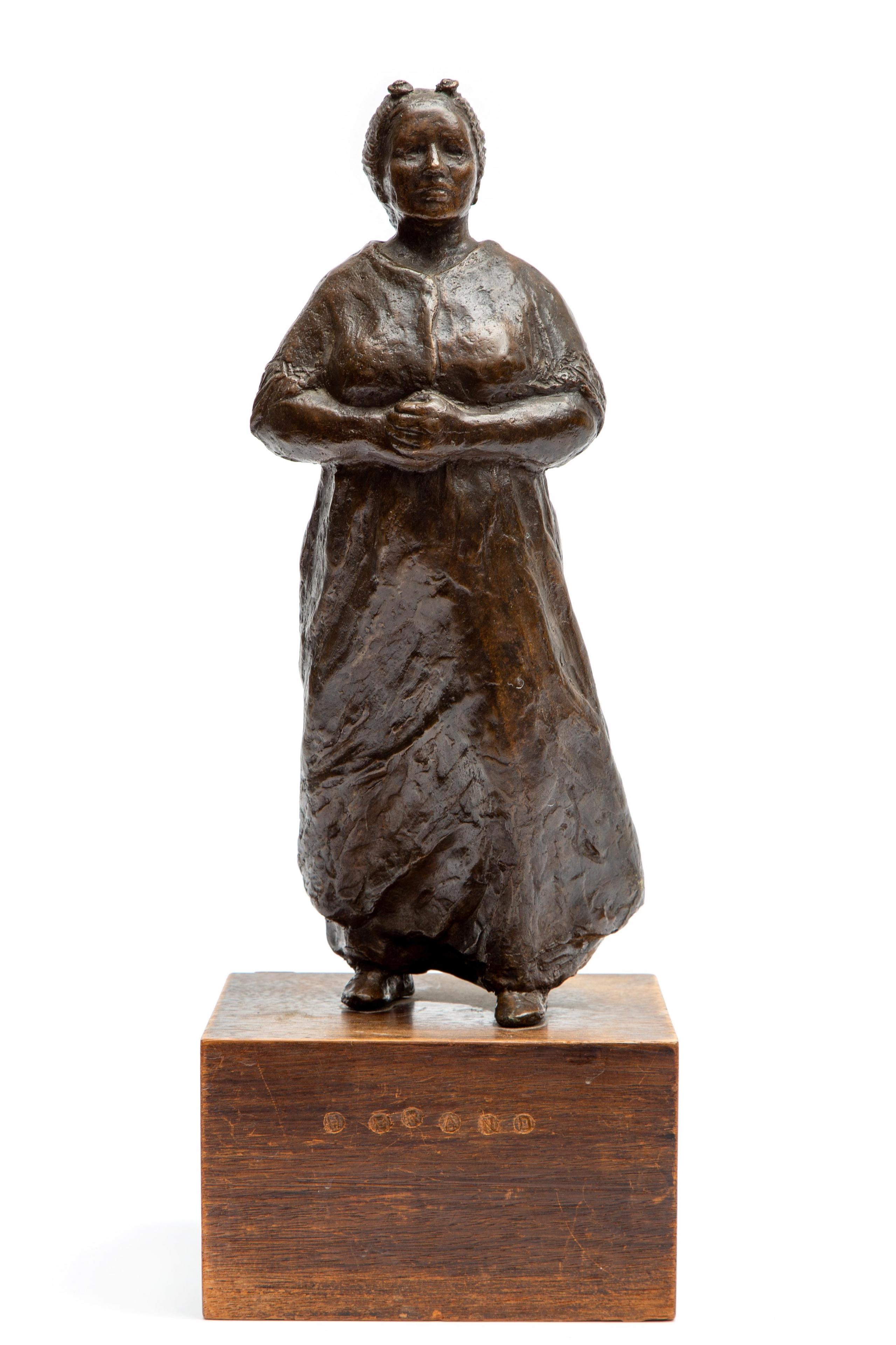 Artwork by Gerard Bakker, Scheveningse vissersvrouw, Made of Bronze, mounted on a wooden base.