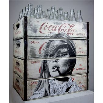 A stacked arrangement of vintage beverage crates featuring a striking black-and-white portrait and glass bottles.