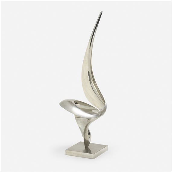 A sleek, silver abstract sculpture with a soaring, wing-like form resting on a square base.