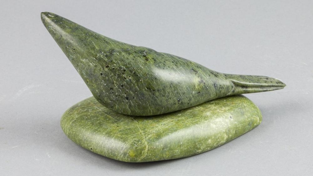 Artwork by Tukiki Manomie, a green stone carving of a seal, Made of green stone