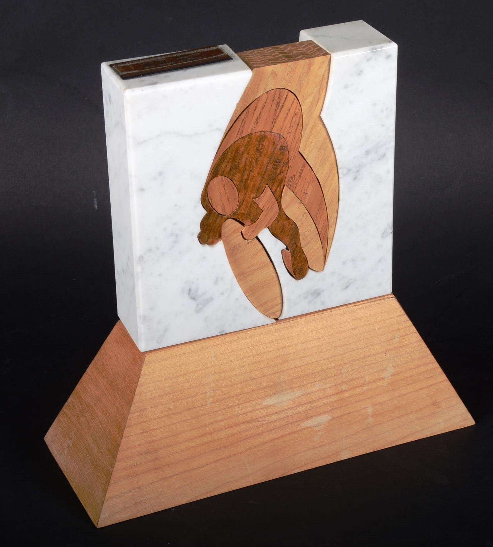 Artwork by Gérard Wibin, Trophée du Vélodrome, Made of Assembly of pieces of wood in two carved marble blocks representing the final work of a cyclist on a track, on a wooden base