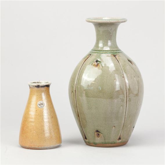 a stoneware bottle covered in green glaze with incised decoration