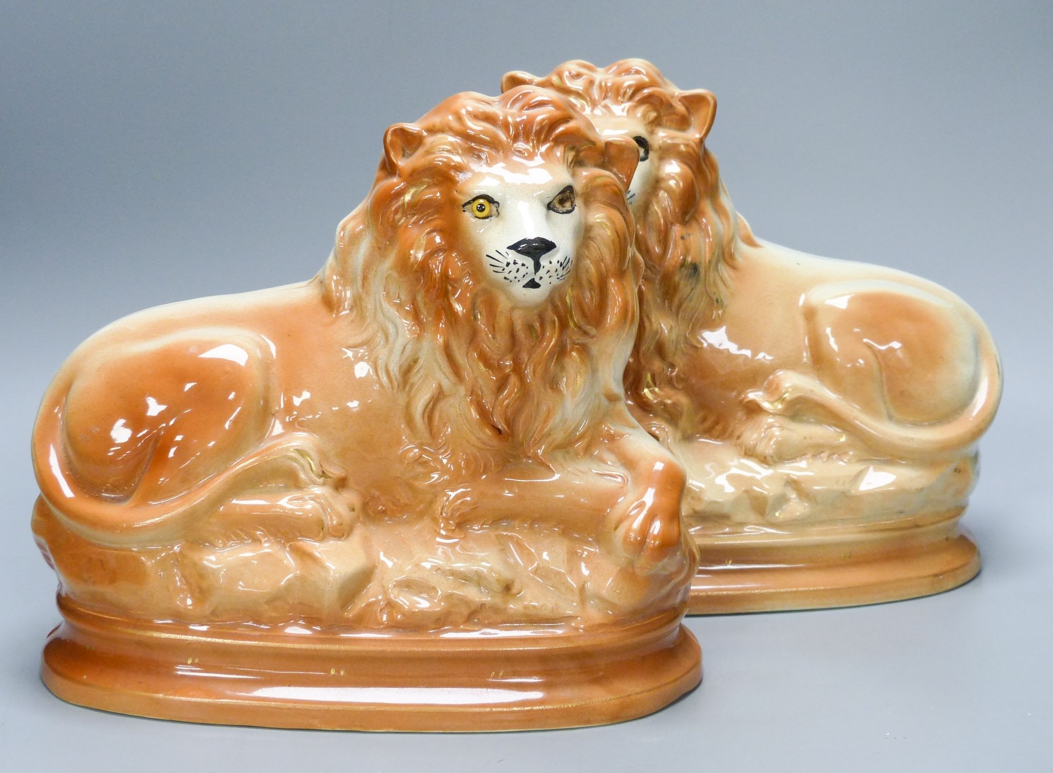 A pair of Staffordshire pottery 'lion' figures by Staffordshire