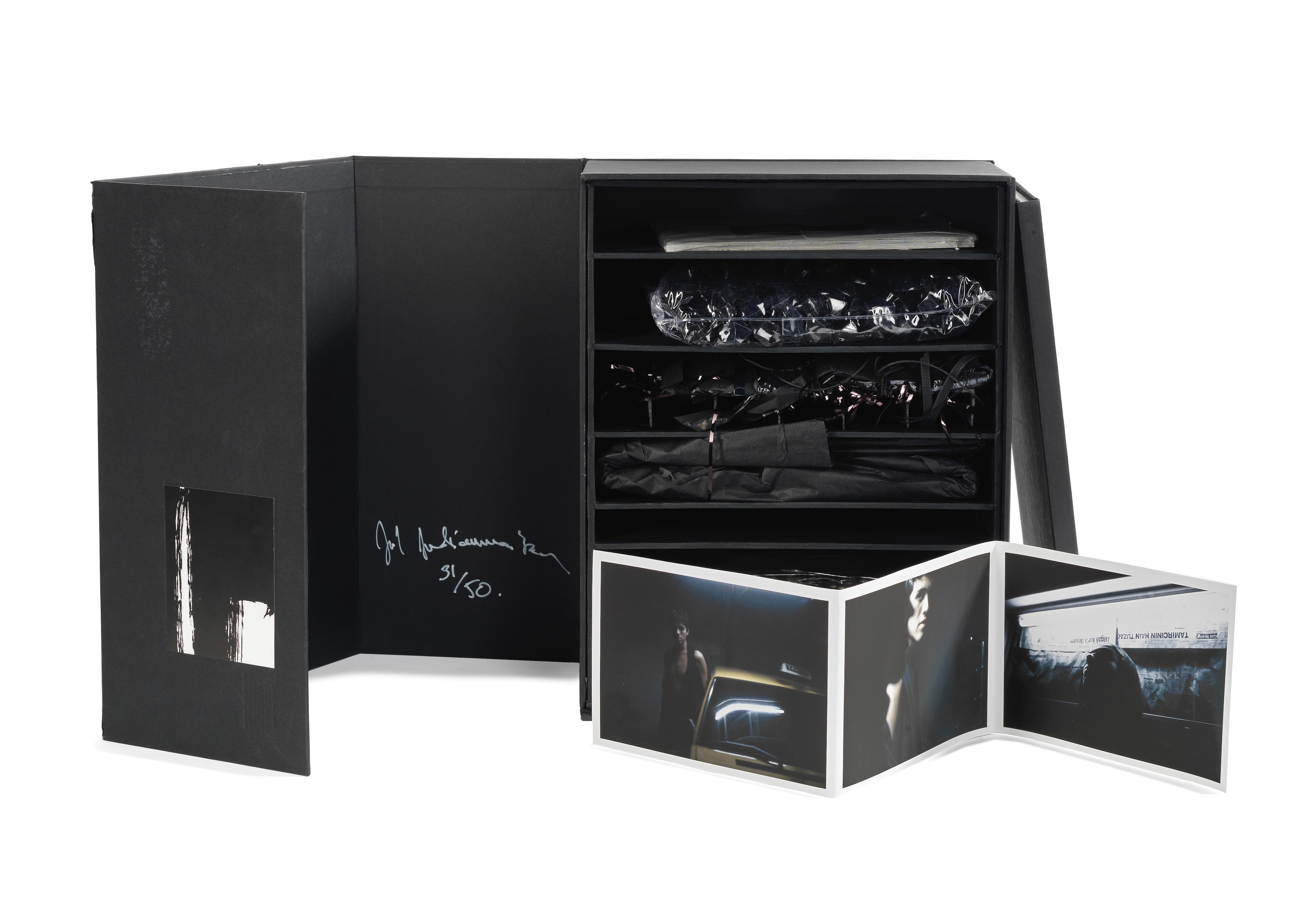 Artwork by Joël Andrianomearisoa, Box, Made of set of 20 black cards, a set of plastic black diamonds, a mixed-media sculpture, a collage black paper folder, a set of three photographs, 72 handmade dominoes, and a textile piece; together with the book