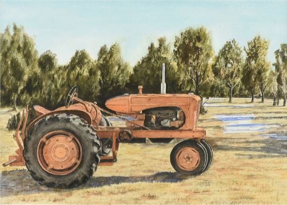 A vintage orange tractor rests on dry grass under a bright sky.
