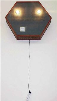 A hexagonal wall-mounted light fixture with a textured surface, glowing bulbs, and a dangling power strip.