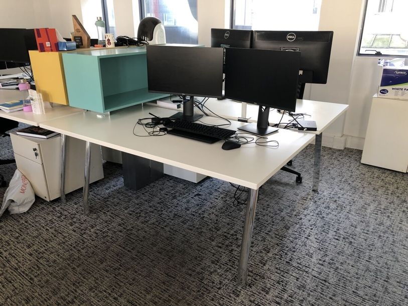 2 double desks, top in cream laminate, common base in aluminum arch, joined by a metal computer gutter by Michele de Lucchi
