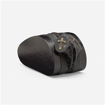 A sculptural composition featuring a black, rounded form with a rough, dark fur-like texture and metallic crosses.