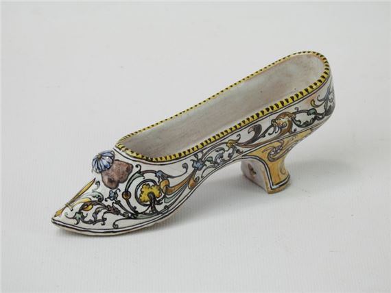 Earthenware shoe decorated with polychrome interlacing on a white background