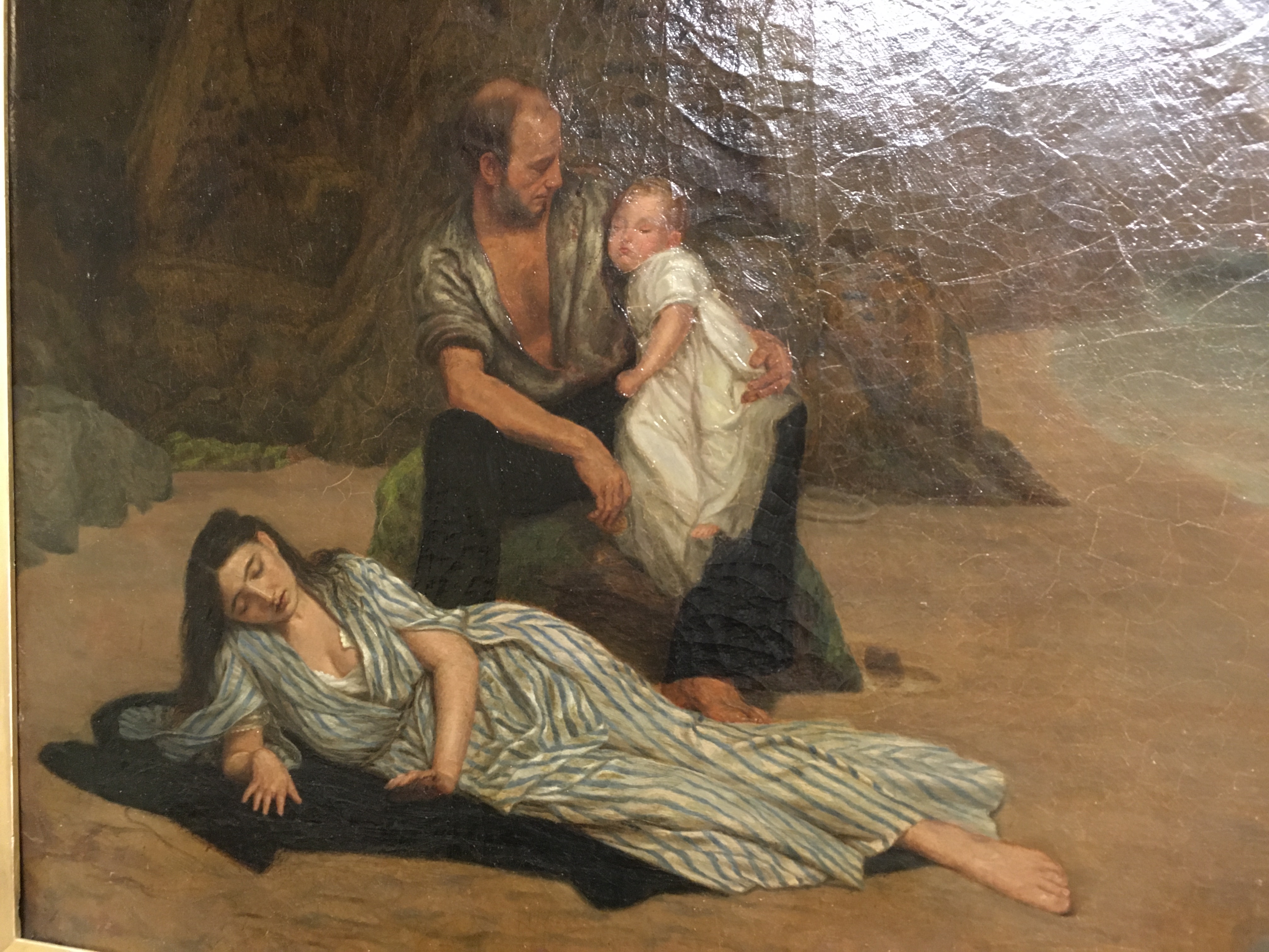 Artwork by Blerritt Darling, "Shipwrecked", a study of a father and child with mother laying on a coat in foreground on a beach, Made of oil on canvas