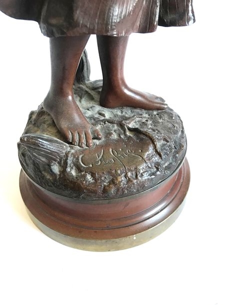 Artwork by Charles Anfrie, Young girl with basket reading, Made of bronze with brown patina
