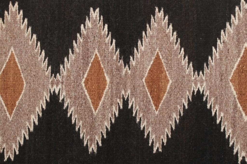 Artwork by Mae Benally, Navajo Eye Dazzler Crownpoint rug, Made of Dyed colors of light brown, black, grey, heathered grey, and cream set to a black field.
